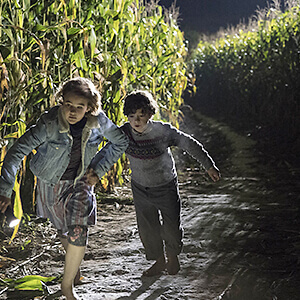 Regan and Marcus Abbott run from the monsters through their corn field